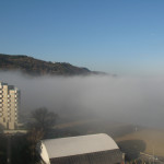 La nebbia copre la spiaggia e i primi palazzi in Baia