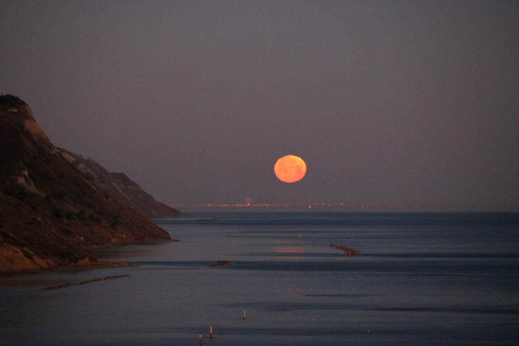 Luna al tramonto sul mare in Baia Flaminia