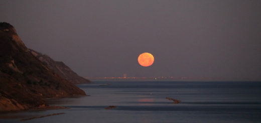 Luna al tramonto sul mare in Baia Flaminia